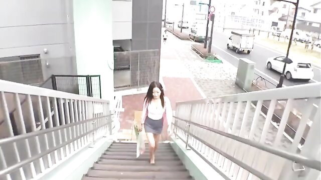 Busty Japanese babe in skirt walks up stairs outdoors
