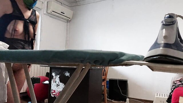 Sexy brunette MILF in sheer lingerie irons topless showing big tits