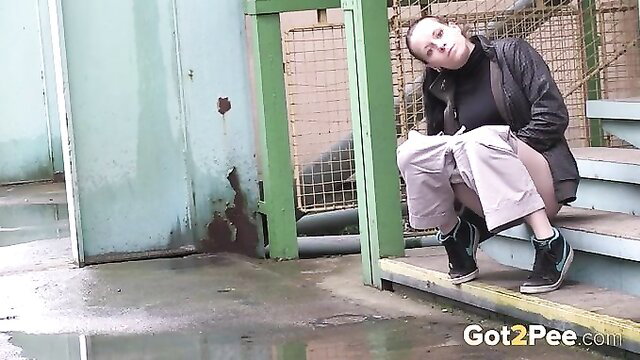 Kinky brunette squats on stairs showing off outdoor pee skills
