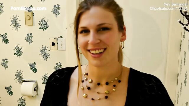 Xev Bellringer smiling in bathroom, big tits, curvy in black top