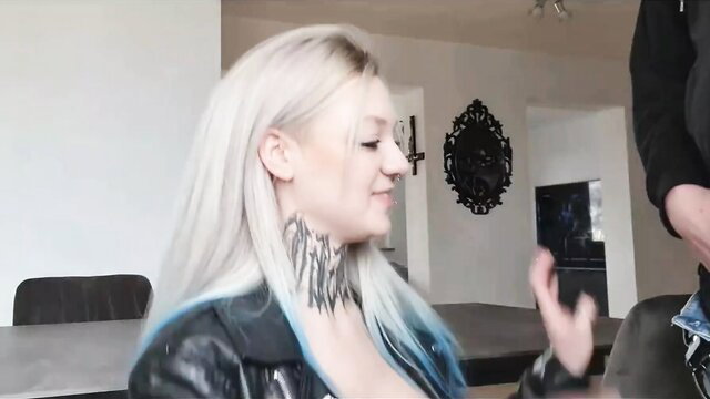 Blonde German tattooed babe in leather jacket smiles at camera