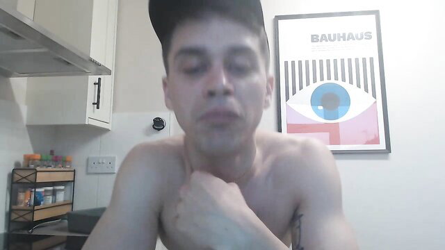 Shirtless young man flexing muscles in kitchen cam show