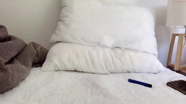 Hot slut on messy bed with pillows, phone and pen nearby