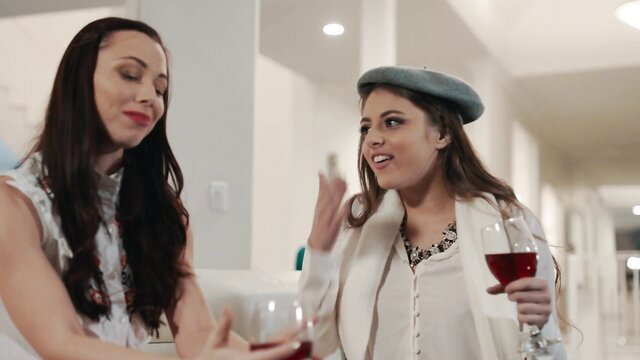 Anna Lynn and brunette friend chatting intimately with wine glasses