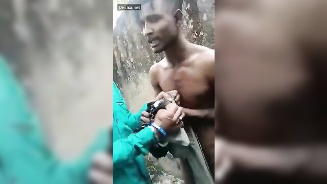 Indian man handcuffed shirtless by woman in rain outdoors