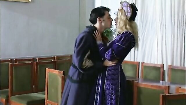 Blonde in purple Renaissance gown passionately kisses androgynous man in coat