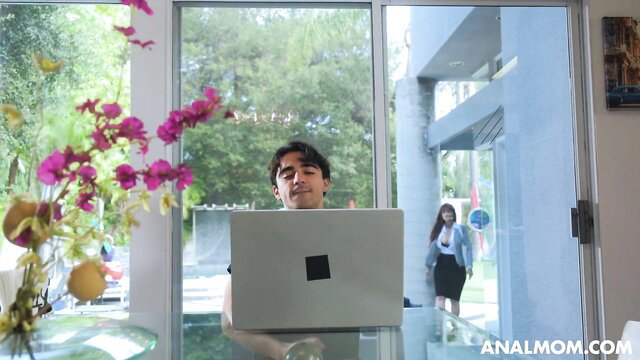 Curly-haired Latino guy at desk with woman in skirt behind, anal mom tease