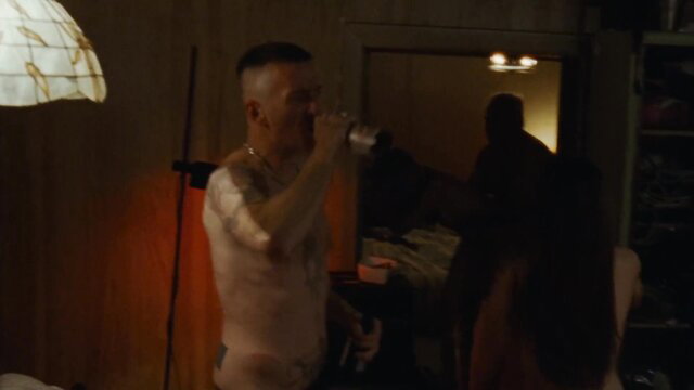 Man drinking from can nude in dimly lit sex scene orgy