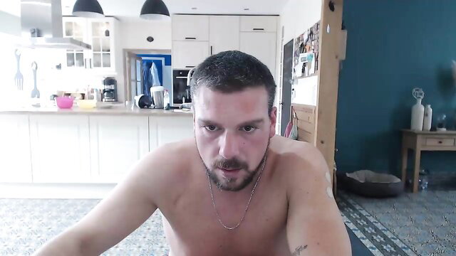Naked muscular man with beard in closeup body exam webcam view