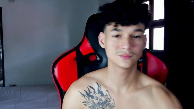 Hot shirtless Asian guy Morthy_downey with flame tattoo in gaming chair