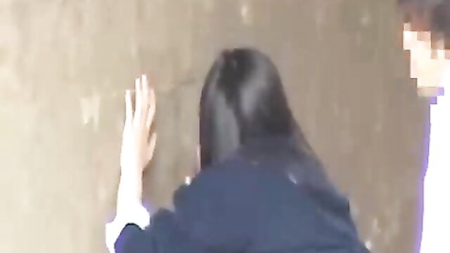Chinese student dark hair pressed against wall by guy in public