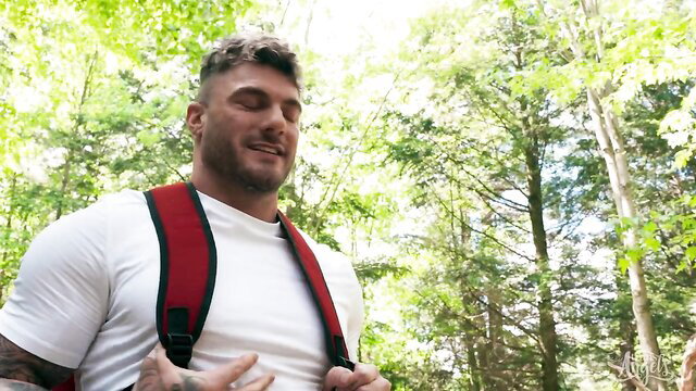 Muscular William Seed hikes with backpack in forest Bella Joie scene
