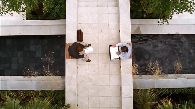 Two suited men in tense outdoor meeting, classic Out of Order 2003 scene