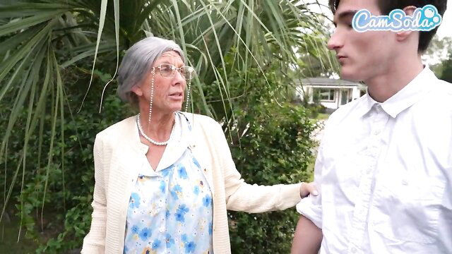 Mature grey-haired grandma chats with young man outdoors in dress