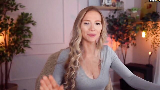 Blonde MILF Bebahan in tight gray cleavage top, gesturing seductively