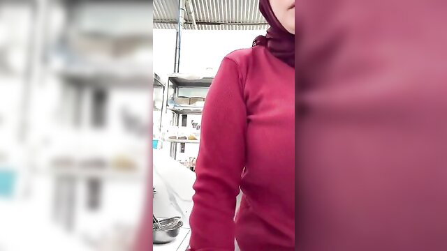 Indonesian hijab auntie in tight red top poses teasingly in kitchen