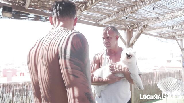 Viktor Rom holds white dog with Manuel Frontera in steamy outdoor gay scene