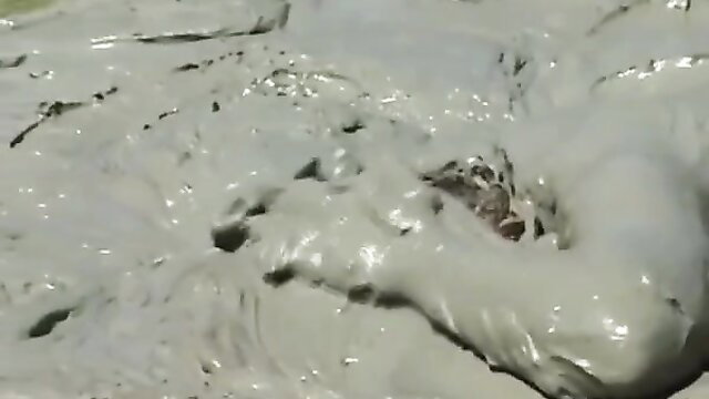 Mud-covered woman in a steamy bath