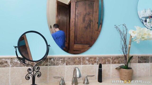 Danni Rivers in blue shirt at mirror in bathroom, Nina Elle