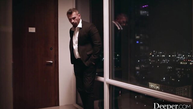 Anton in suit by window in Deeper hotel scene with Lulu Chu
