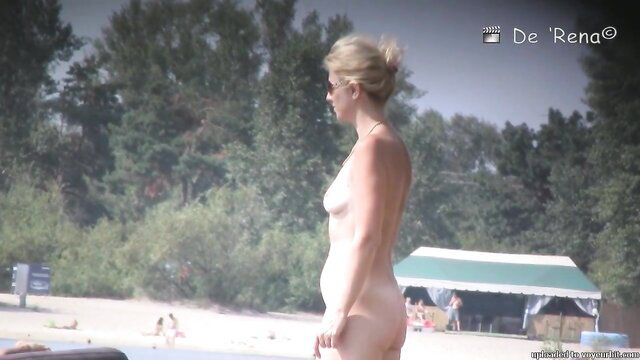 Blonde nudist MILF with big tits walking on beach candid
