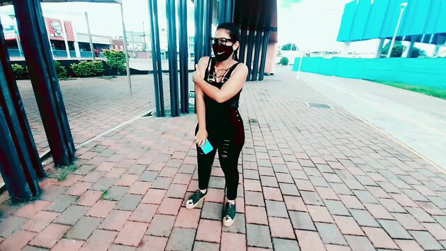 Latina teen in tight black bodysuit and mask holds cash outdoors, money for blowjob