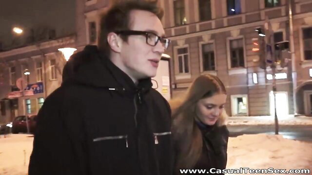 Couple in hoodies and glasses walking snowy night street