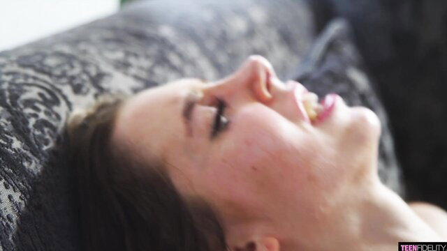 Skinny teen babe with open mouth lying back on couch in ecstasy