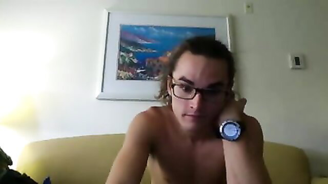 Nude muscular man with long hair poses topless on couch in homemade video