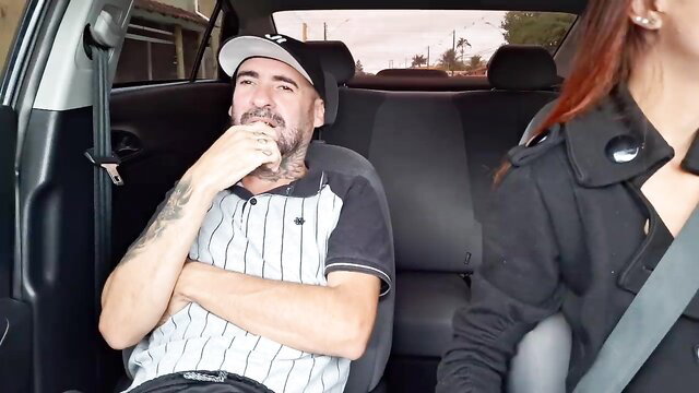 Horny delivery driver in cap smirks at hot redhead passenger in car