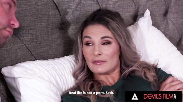 Mandy Rhea looking surprised lying in bed with a man