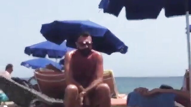 Hairy dude spies on daddy's muscular beach body under umbrellas