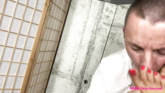 Asian domme teases sub's mouth with red toes, foot fetish tease