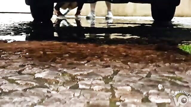 Voyeur spies girl squatting to piss on wet street, sneakers visible