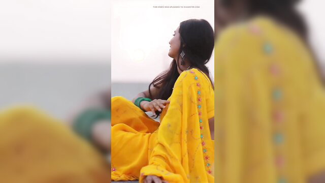 Desi village girl in yellow saree outdoor, smiling beauty