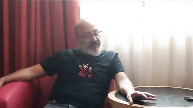 Bald Mexican actor with beard in casual interview shirt, relaxed pose