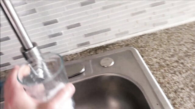 Sophie Tyler fills glass with water in kitchen sink - Sick Day Step Sister