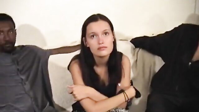 White teen with dark hair sits between two black men in interracial gangbang preview