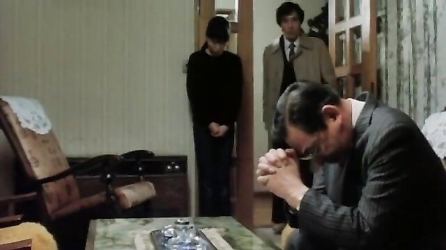 Three suited Asian men praying in tense indoor scene