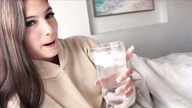 Sophie Tyler in hoodie holding iced water on bed, Sick Day Step Sis