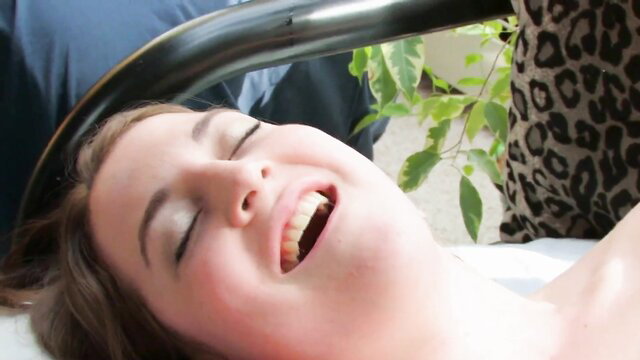 Smiling brunette woman nude on table under beauty lamp in erotic video