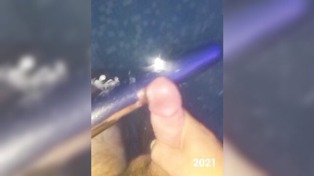 Blurry closeup of hand stroking erect penis on blue surface amateur solo