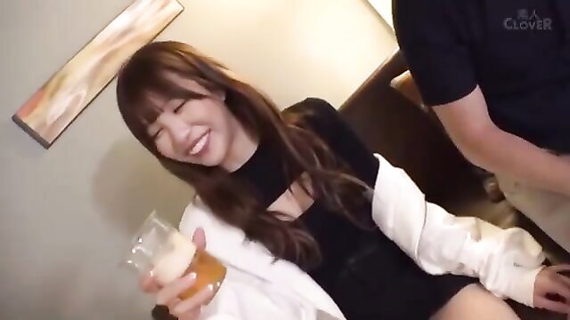 Asian JAV babe with bangs smiles holding beer, cleavage exposed in clubwear