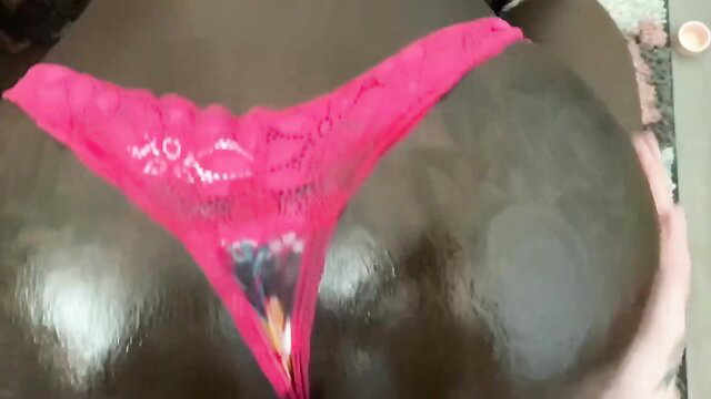 Ebony babe spreads in pink lace thong, exposing wet pussy closeup
