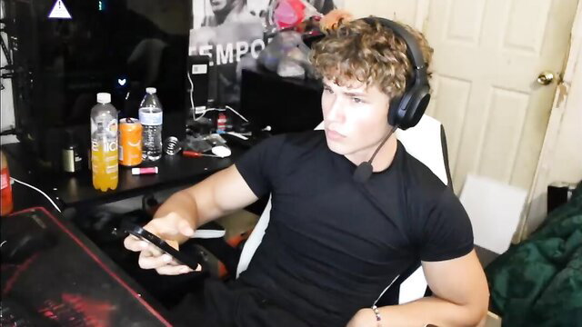 Muscular curly-haired guy in tight black tee at gaming desk, leaked butt porn thumbnail