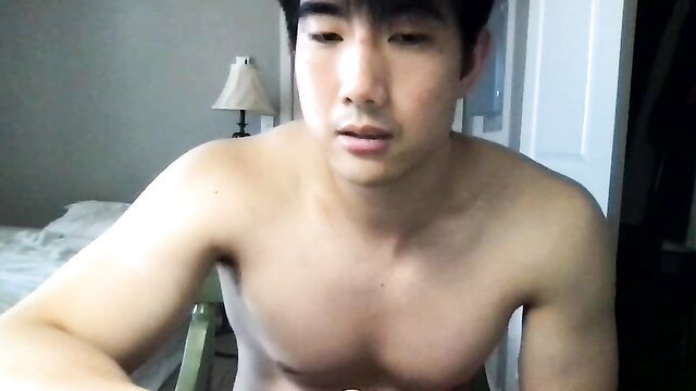 Shirtless Asian twink flexing muscles in bedroom webcam tease