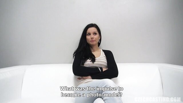 Petra at casting interview, brunette in tank top and jeans on couch