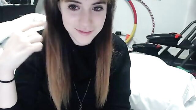 Cute amateur webcam teen girl with long brown hair holding Wii controller