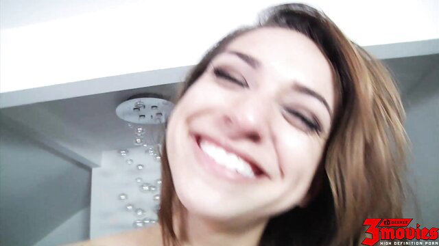 Smiling brunette babe winking in shower, wet nude tease