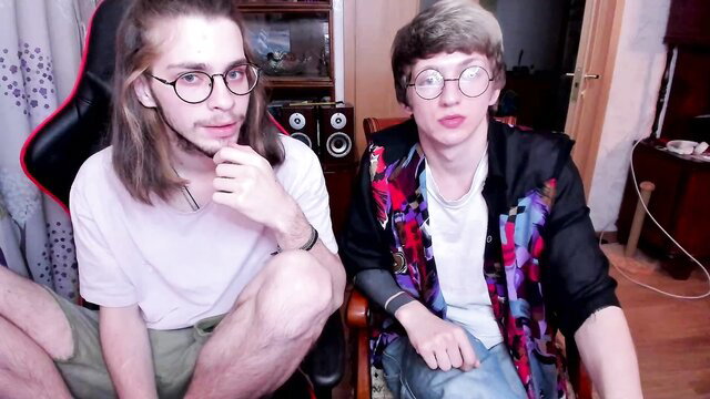 Two young twinks in glasses, casual clothes, amateur gay chat pose